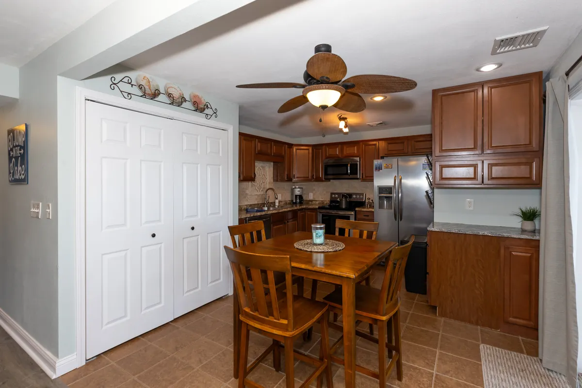 A cozy kitchen table surrounded by cabinetry and appliances, with a welcoming ambiance that hints at family gatherings and shared meals. Decorative elements enhance the homey feel, suggesting a place where traditions are made and stories are shared.