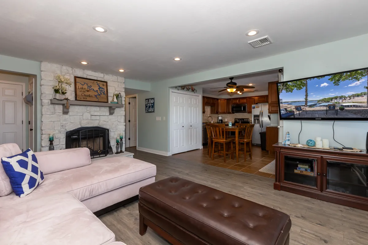 A spacious, inviting living area featuring a plush sofa, a warm fireplace, a large television, and an adjacent dining area. The room is set up for gatherings, with comfortable seating and a layout that encourages conversation and togetherness.