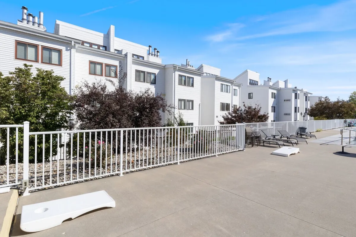 An inviting exterior scene featuring modern architecture, a landscaped area, and comfortable seating arrangements. The image captures a patio or outdoor lounge space suitable for relaxing after a day on the lake, with hints of sunset lighting that add warmth to the atmosphere.
